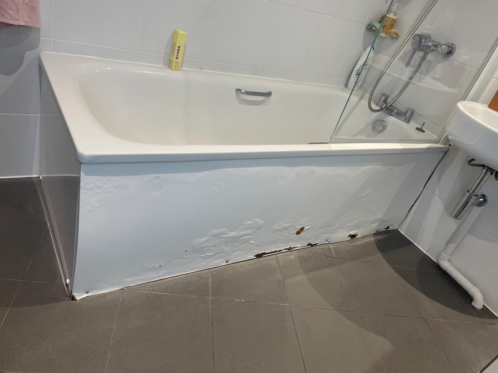Damaged and water-stained bath panel in a bathroom, NW4
