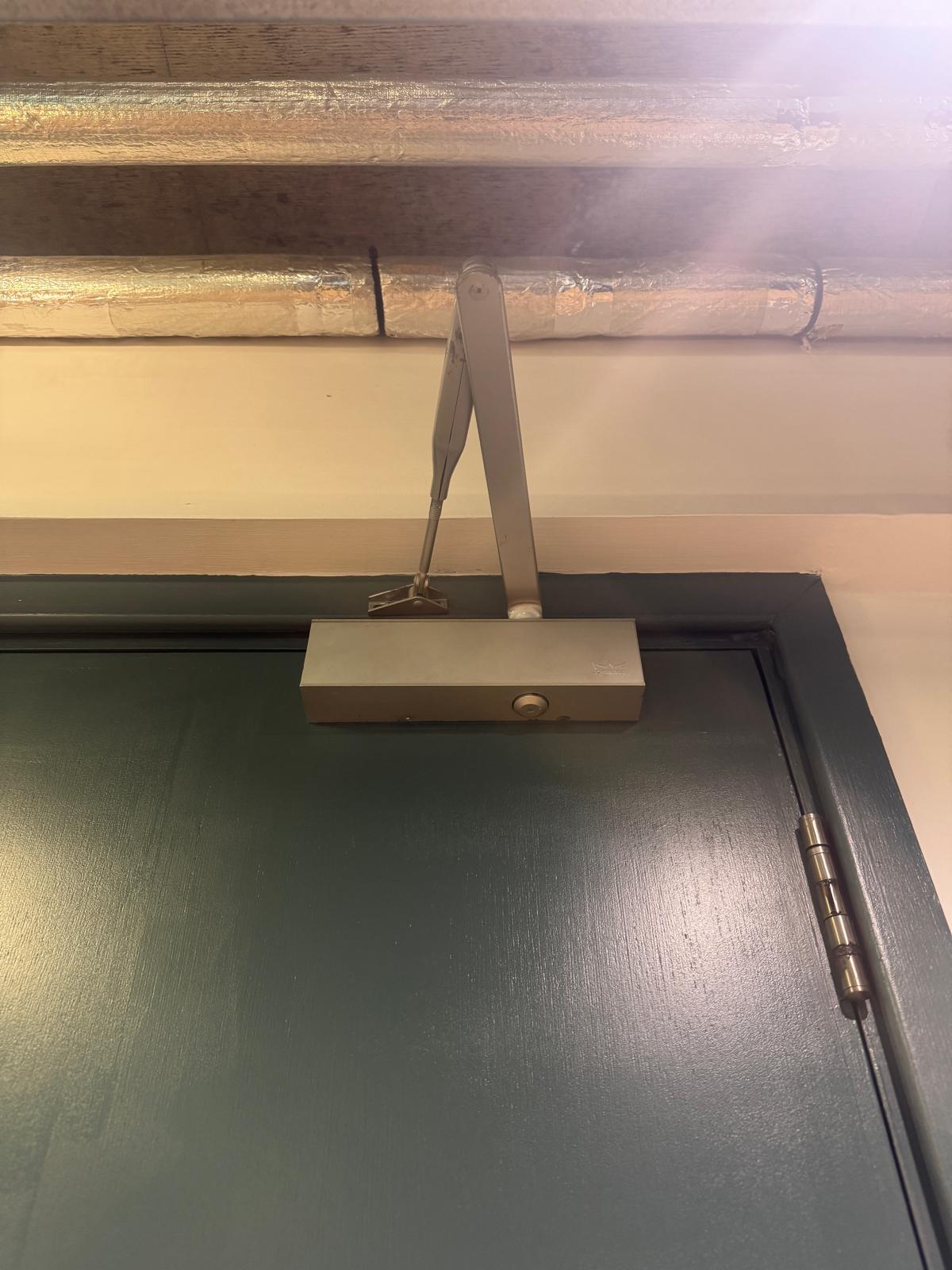 Overhead door closer fitted to the top of an internal door, Harrow HA2